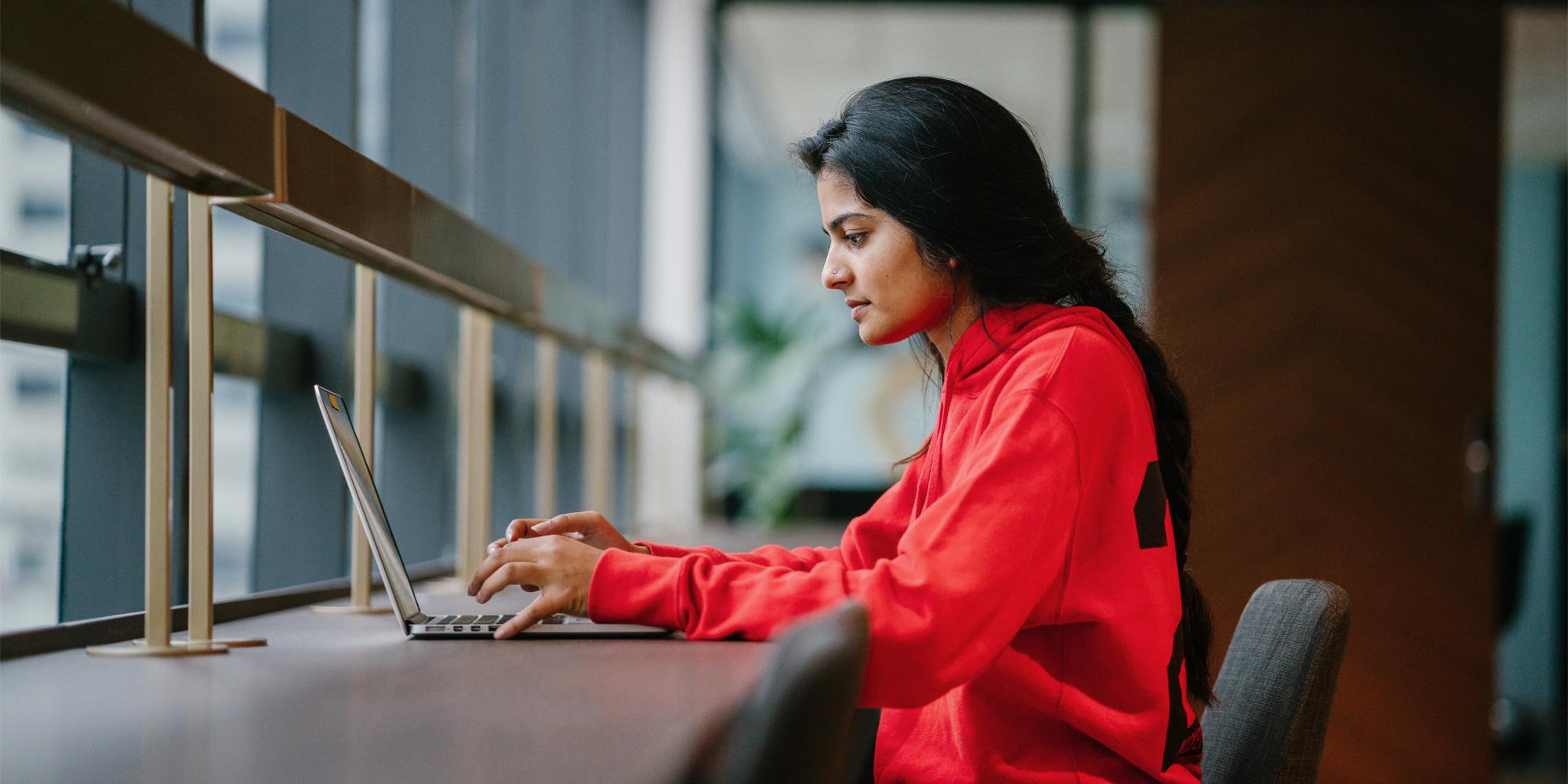 Woman in red shirt at a laptop